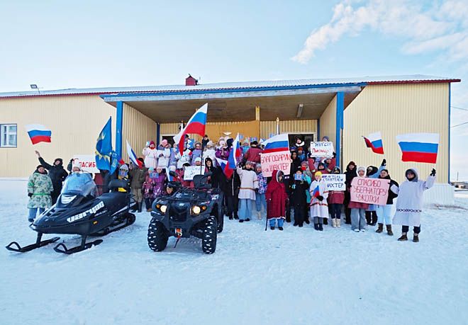 Воспитанники Центра образования села Рыркайпий встретили участников церемонии передачи оленеводам техники и снаряжения плакатами, транспарантами и флагами. ФОТО: T.ME/VLADISLAV_KUZNECOV