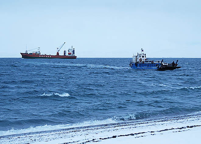 Разгрузка «Вячеслава Анисимова» в селе Лаврентия на необорудованный берег традиционно производилась с помощью самоходного плашкоута. ФОТО: НАТАЛЬЯ ГРИГОРЬЕВА