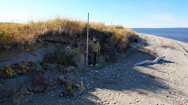 Археолог Елена Рогозина у участка берегового обрыва с культурным слоем на правом берегу реки Анадырь, сентябрь 2025 года.
